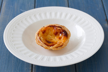 portuguese egg cookie on white dish on blue background