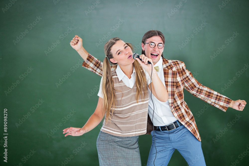 Poster composite image of happy geeky hipsters singing with microphone