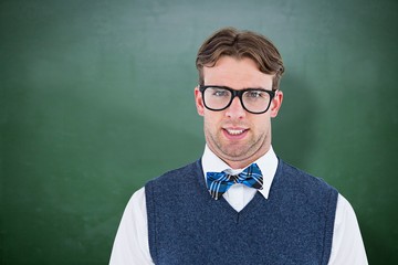Composite image of geeky hipster looking at camera 