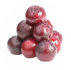 Isolated cherries lie on each other in a pyramid with water drop.