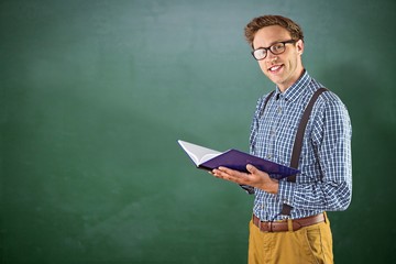 Composite image of geeky student reading a book