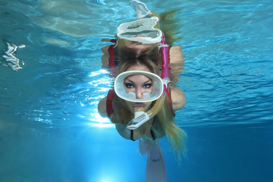 Sexy female snorkeler swimming with neoprene swimsuit underwater 