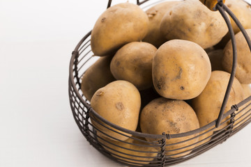 uncooked potatoes in wire basket