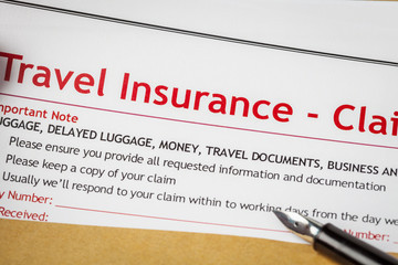 Fototapeta premium Travel Insurance Claim application form and human hand with pen
