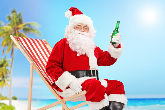 Santa Claus Holding A Bottle Of Beer On A Beach