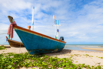 Fototapeta premium Fishing boat on sand beach and blue sky