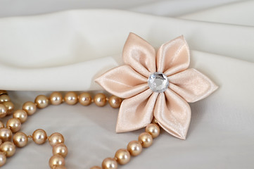 Handmade kanzashi flower and pearls on white background