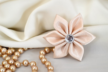 Fototapeta na wymiar Wedding accessories. Handmade silk kanzashi flower and pearls