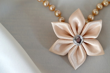 Fototapeta na wymiar Wedding accessories: Handmade silk fabric flower as a pendant