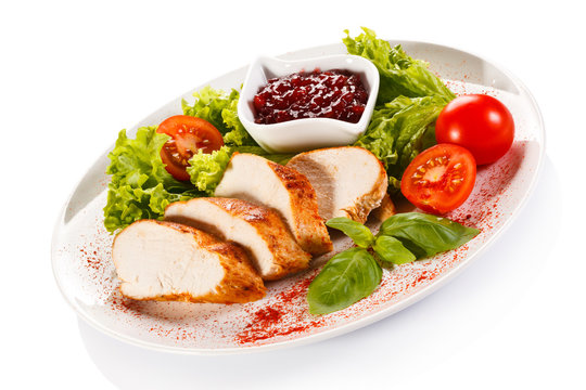Roast chicken fillet and vegetables on white background 