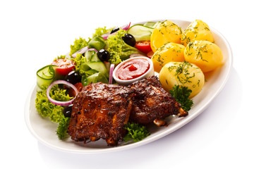 Grilled ribs, French fries and vegetables on white background 