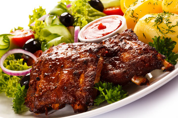Grilled ribs, French fries and vegetables on white background 