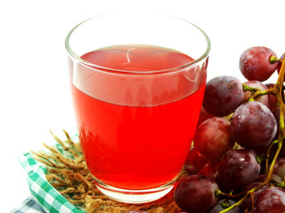 glass of red grape juice with fruit isolated on white background