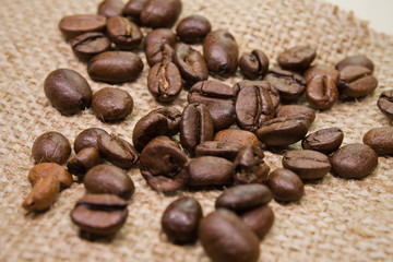 coffee beans scattered on sackcloth closeup