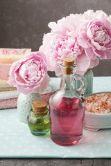 Glass bottle of liquid soap and peonies