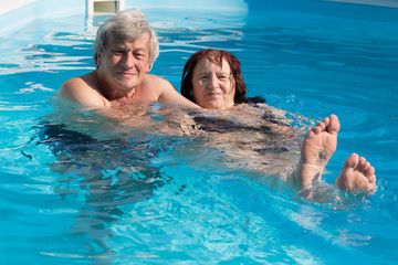 Happy senior couple in a swimming pool