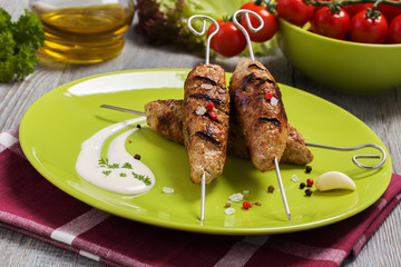 Barbecued kofta - kebeb with vegetables on a plate.