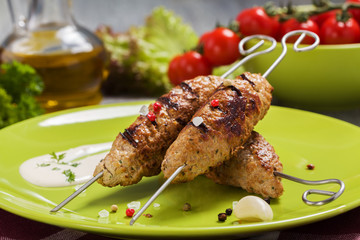 Barbecued kofta - kebeb with vegetables on a plate.