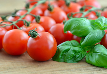 Kirschtomaten mit Basilikum auf Holzküchenbrett