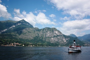 Ferry in Lake Como view towards Menaggio under blue sky in Lombardy Italy 