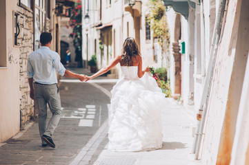 happy young newly married couple walking the old streets of Gree