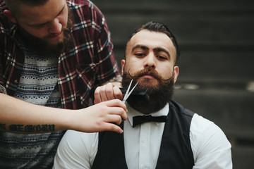 barber shaves a bearded man