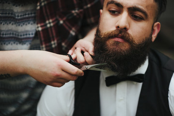 barber shaves a bearded man