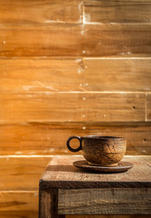 Palm wood coffee cup on wooden table and wooden wall