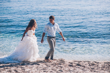 Fototapeta na wymiar Bride and groom by the sea on their wedding day