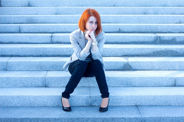 Very sad woman sitting outside and waiting for someone