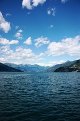 Summer - Lake Como under blue sky with white clouds in Lombardy Italy 