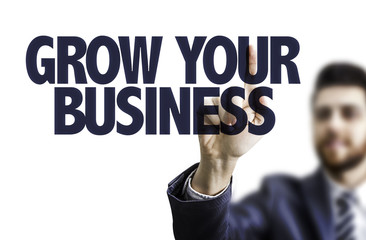 Business man pointing the text: Grow Your Business