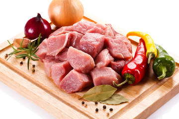 Raw pork chops on cutting board and vegetables 