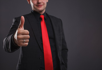 Smiling businessman giving thumbs up in front of his team