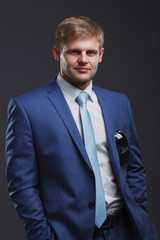 Portrait of a young businessman on a gray background
