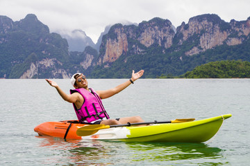 Young Asia man paddling in Chiewlarn dam in Surat Thani, Thailand