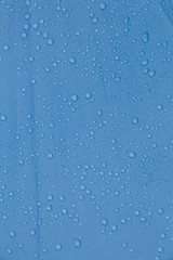 Fototapeta na wymiar Rain Water droplets on blue waterproof fabric