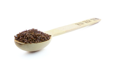 Red rice in a wooden spoon