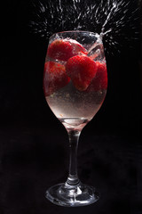 Strawberries in wine glass with water.