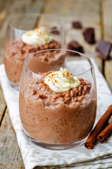 chocolate rice pudding decorated with whipped cream with cinnamo