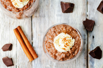chocolate rice pudding decorated with whipped cream with cinnamo