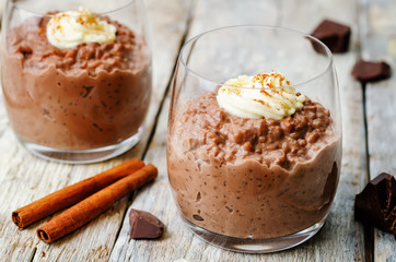 chocolate rice pudding decorated with whipped cream with cinnamo