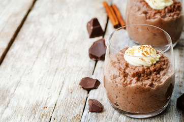 chocolate rice pudding decorated with whipped cream with cinnamo