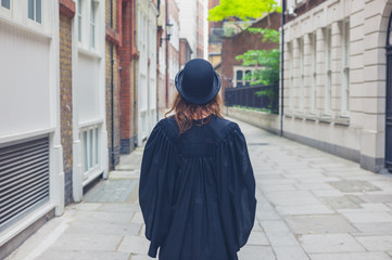 Woman in bowler hat and graduation gown