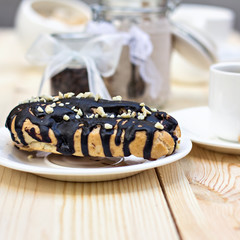 Chocolate cake (eclair) with cup of coffee.  profiteroles with chocolate cream