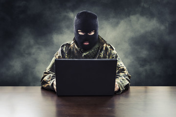 Masked cyber terrorist in military uniform hacking army intelligence - obrazy, fototapety, plakaty
