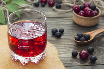 cherry juice , cherries and currants in a wooden spoon