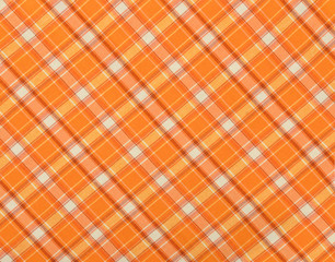 Scottish tartan pattern. Orange and white plaid print as background. Symmetric rhombus pattern.