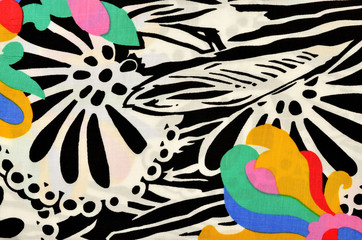 Abstract flower and circles pattern on fabric. Graphic black and white design with a colorful flower print as background.
