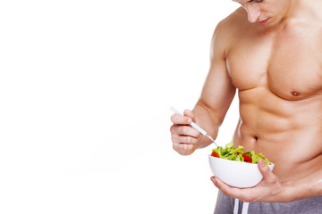 Strong fitness man holding a bowl of salad, isolated on white ba